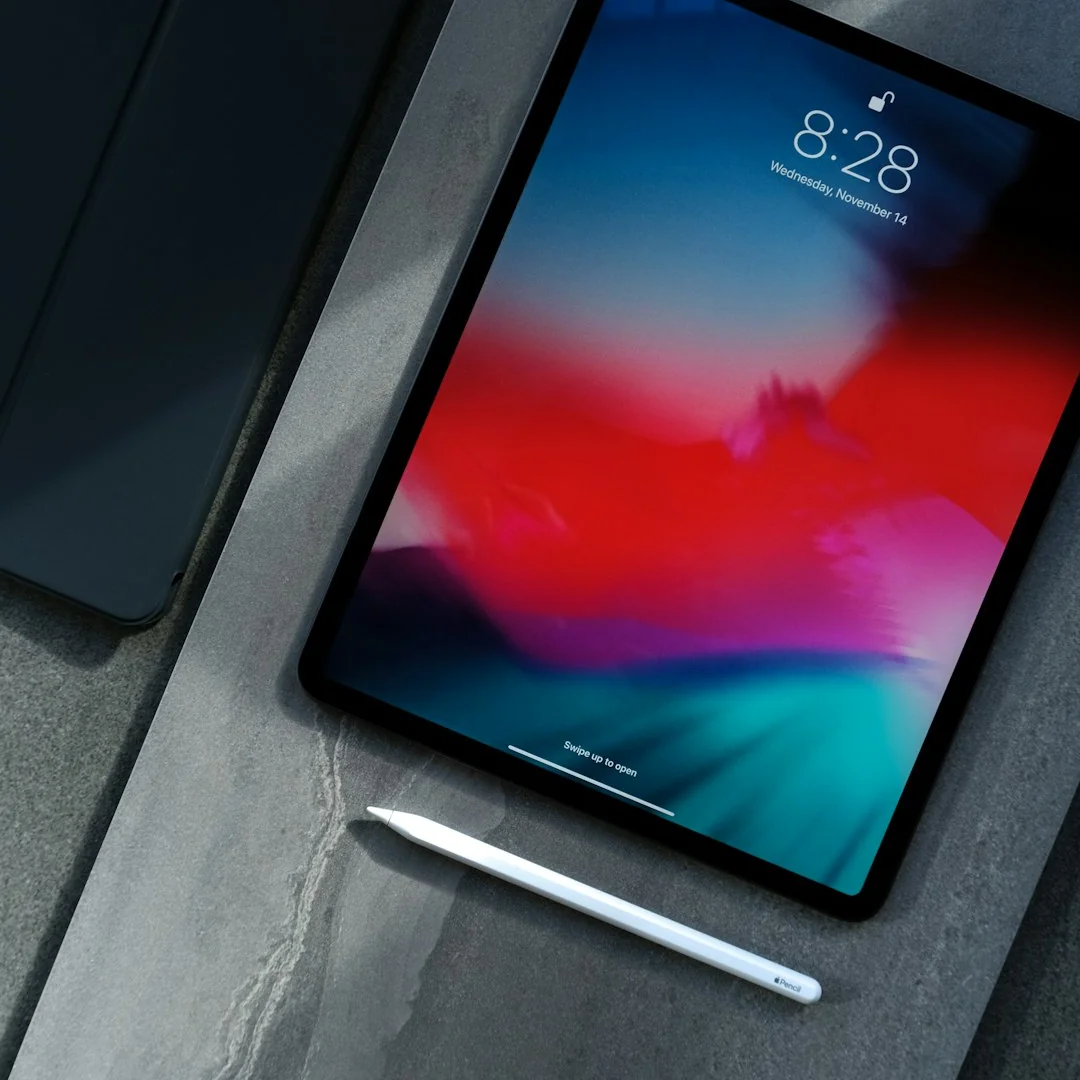 iPad Pro com Apple Pencil sobre mesa de pedra cinza